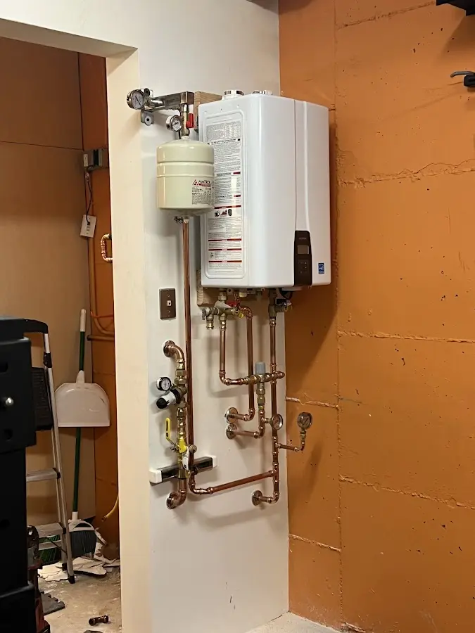 Plumbing technician inspecting water heater connections in Galax